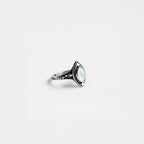 Silver ring with a pearl gemstone on a light gray background