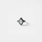 Ring with a pearl gemstone on a light gray background