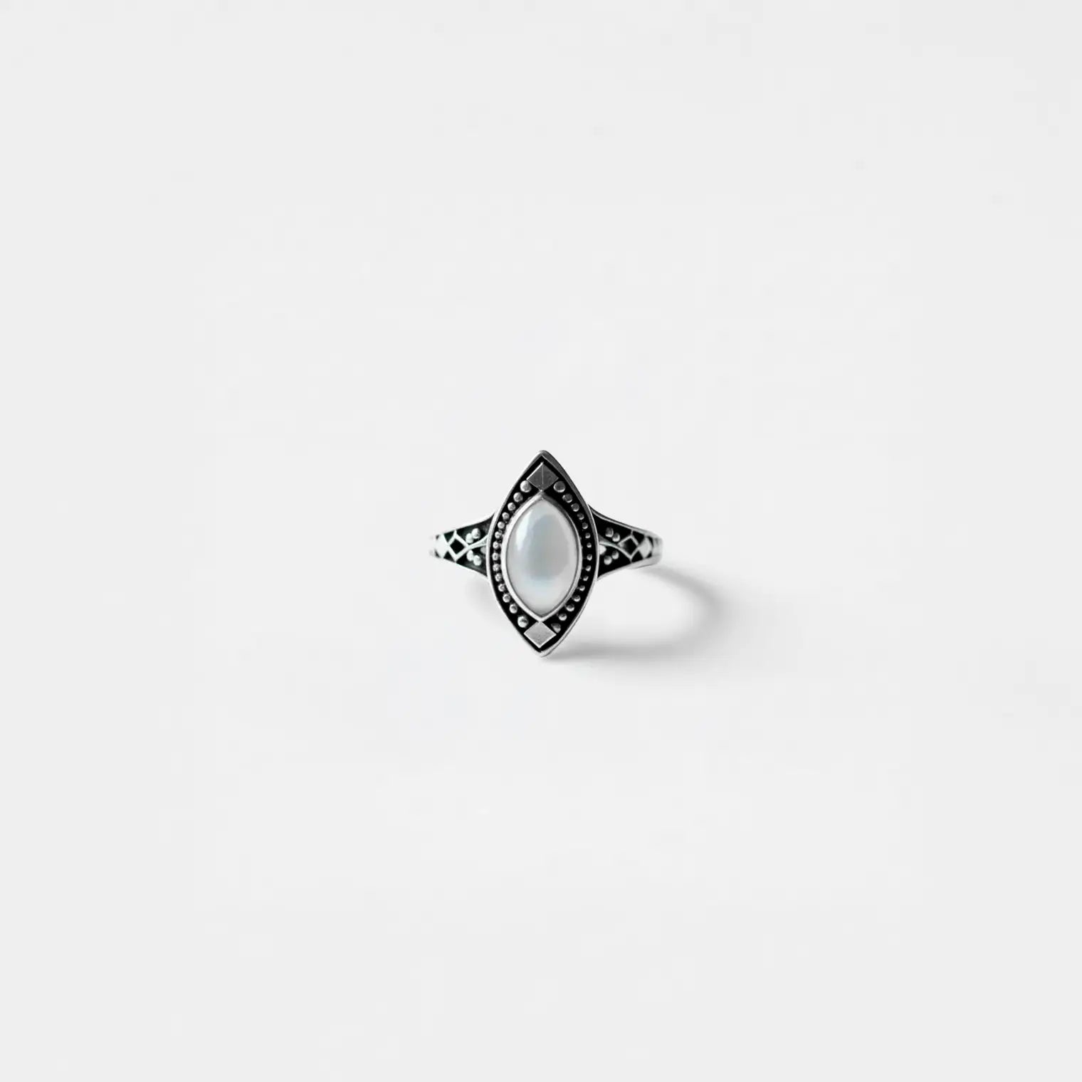 Ring with a pearl gemstone on a light gray background