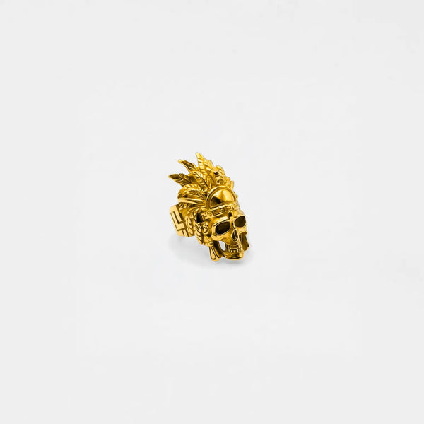 gold ring of a skull wearing a headdress , on a white background
