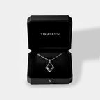 Silver necklace with a black pendant in a Tikalkun box on a light gray background