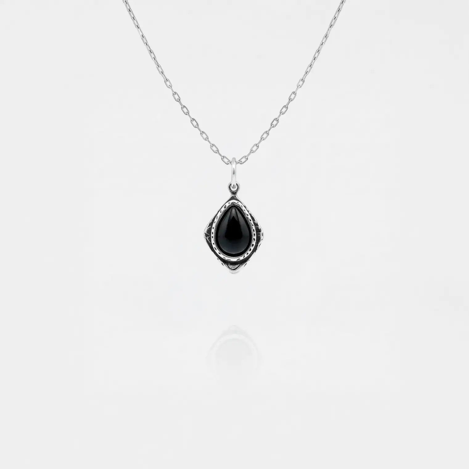 Necklace with a black teardrop pendant on a white background