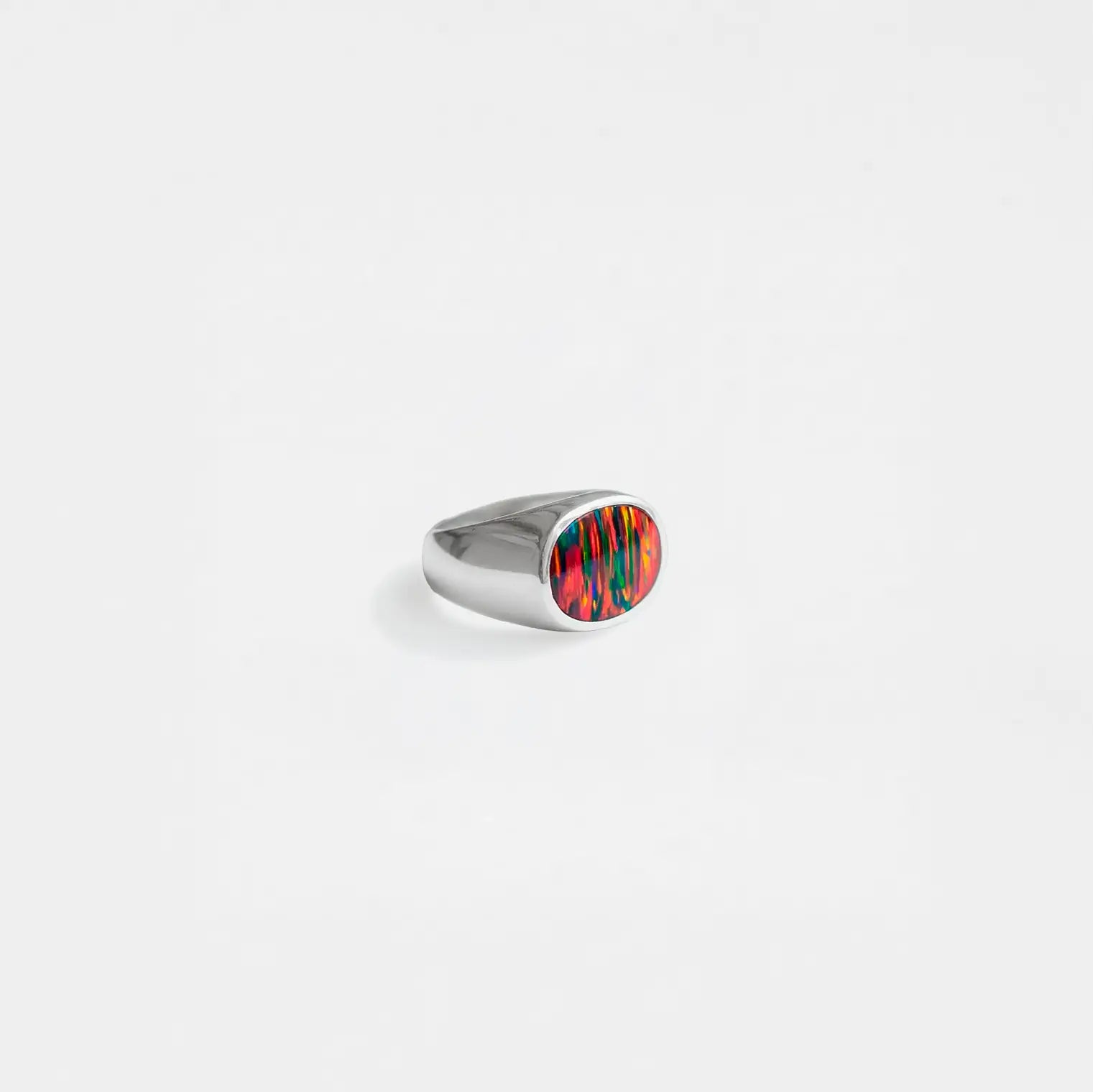 Silver ring with a opal-fire stone on a white background
