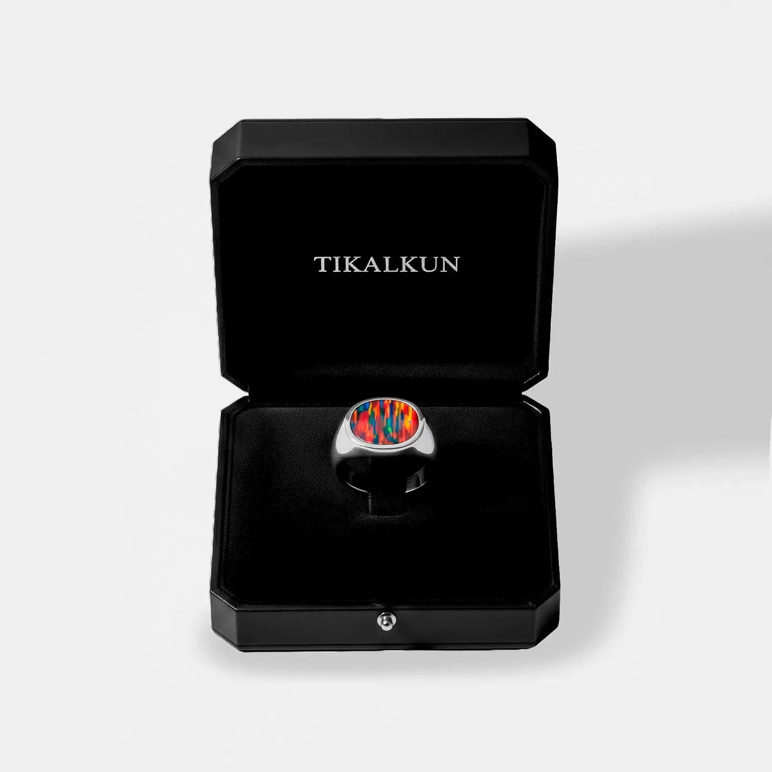 Silver ring with an opal fir design in a black Tikalkun box on a light gray background