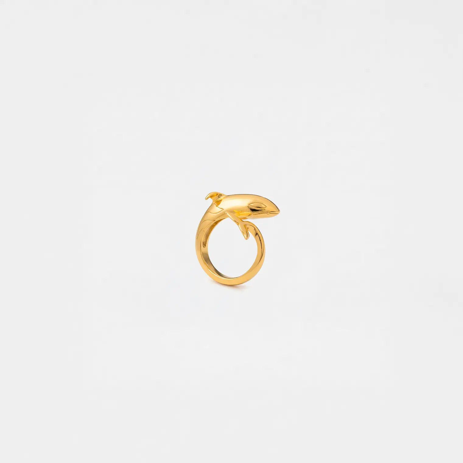 Gold ring with an orca design on a light gray background