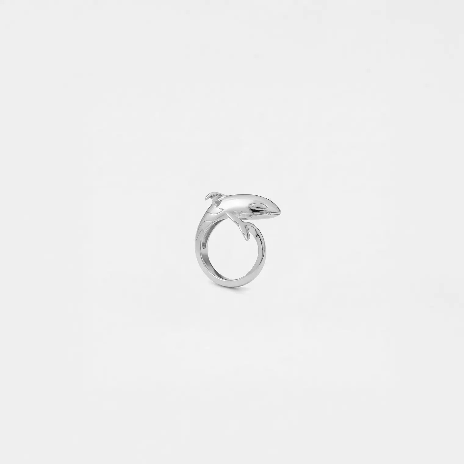 Silver orca ring on a light gray background