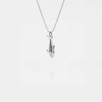 Silver orca pendant on a chain against a white background