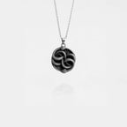 Silver necklace with an ouroboros pendant on a white background