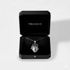 mayan face Silver pendant necklace in a black Tikalkun jewelry box on a light gray background
