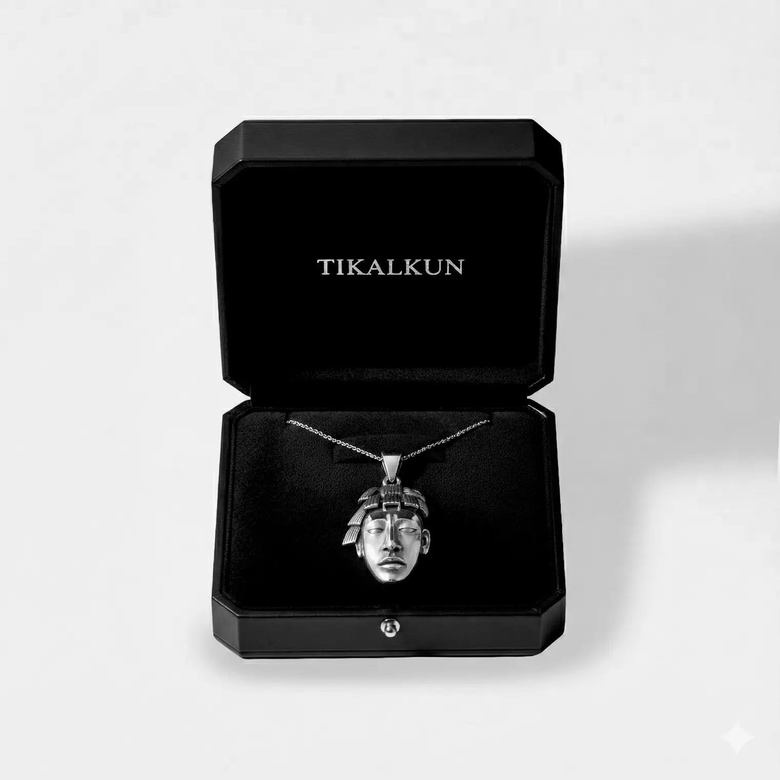 mayan face Silver pendant necklace in a black Tikalkun jewelry box on a light gray background