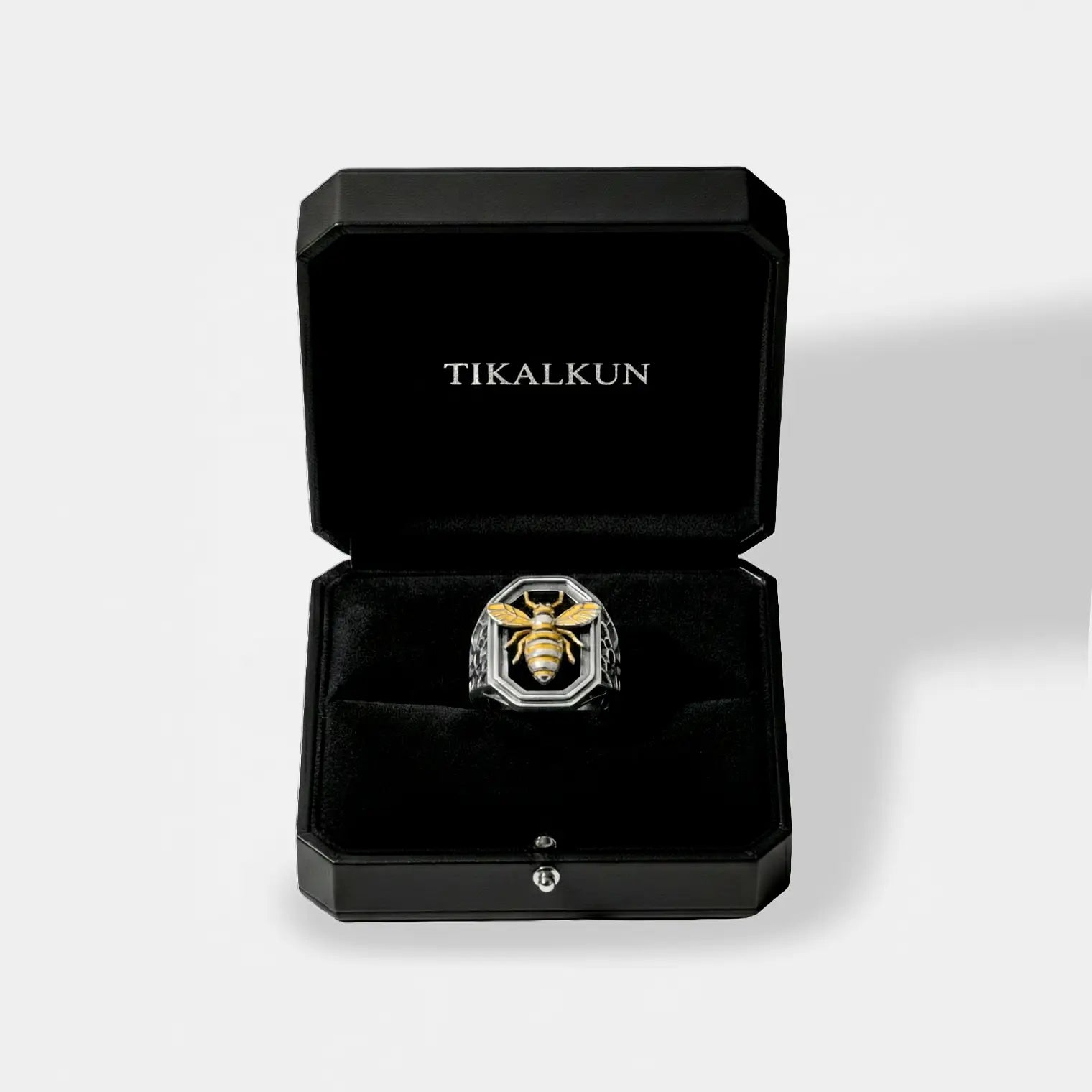 Silver ring with bee design in a black Tikalkun box on a light gray background