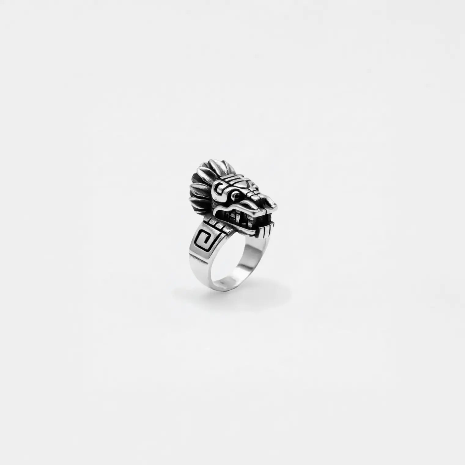 Silver quetzalcoatl ring with intricate design on a white background