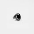 Silver ring with an obsidian stone on a light gray background