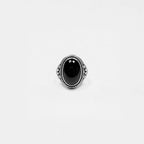 Silver ring with a black gemstone on a white background