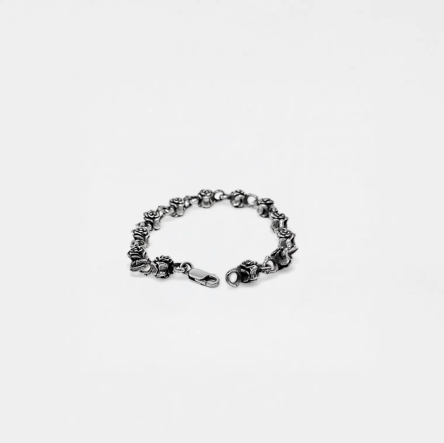 Silver roses bracelet on a white background