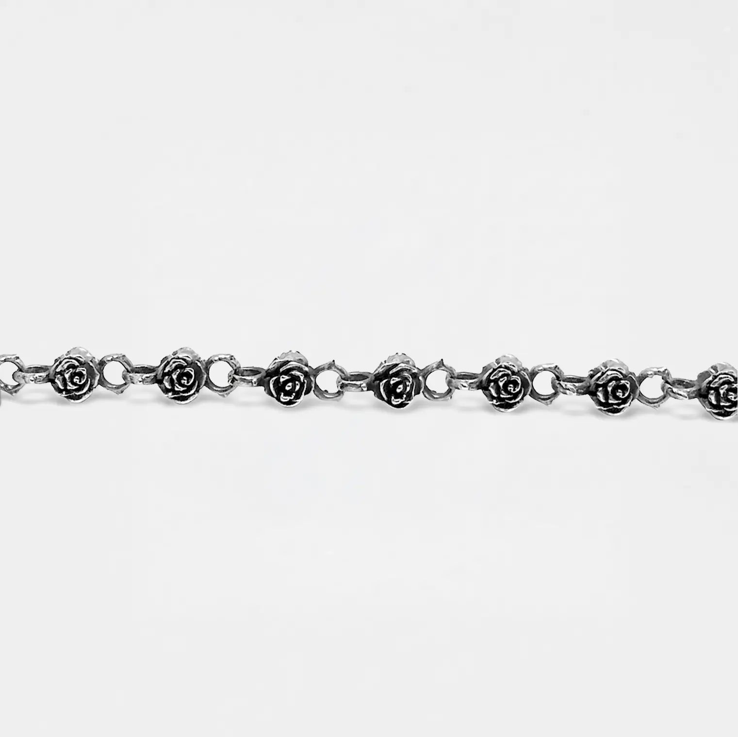 Silver roses bracelet with rose-shaped links on a white background