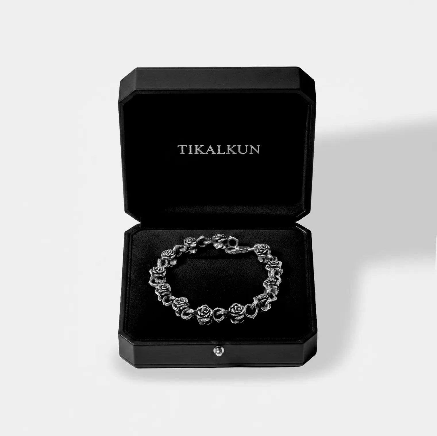 Silver bracelet in a black Tikalkun jewelry box on a light gray background