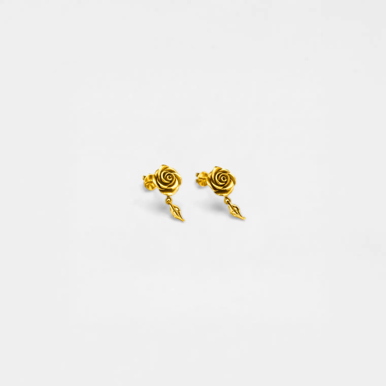 Pair of gold rose-shaped earrings on a white background