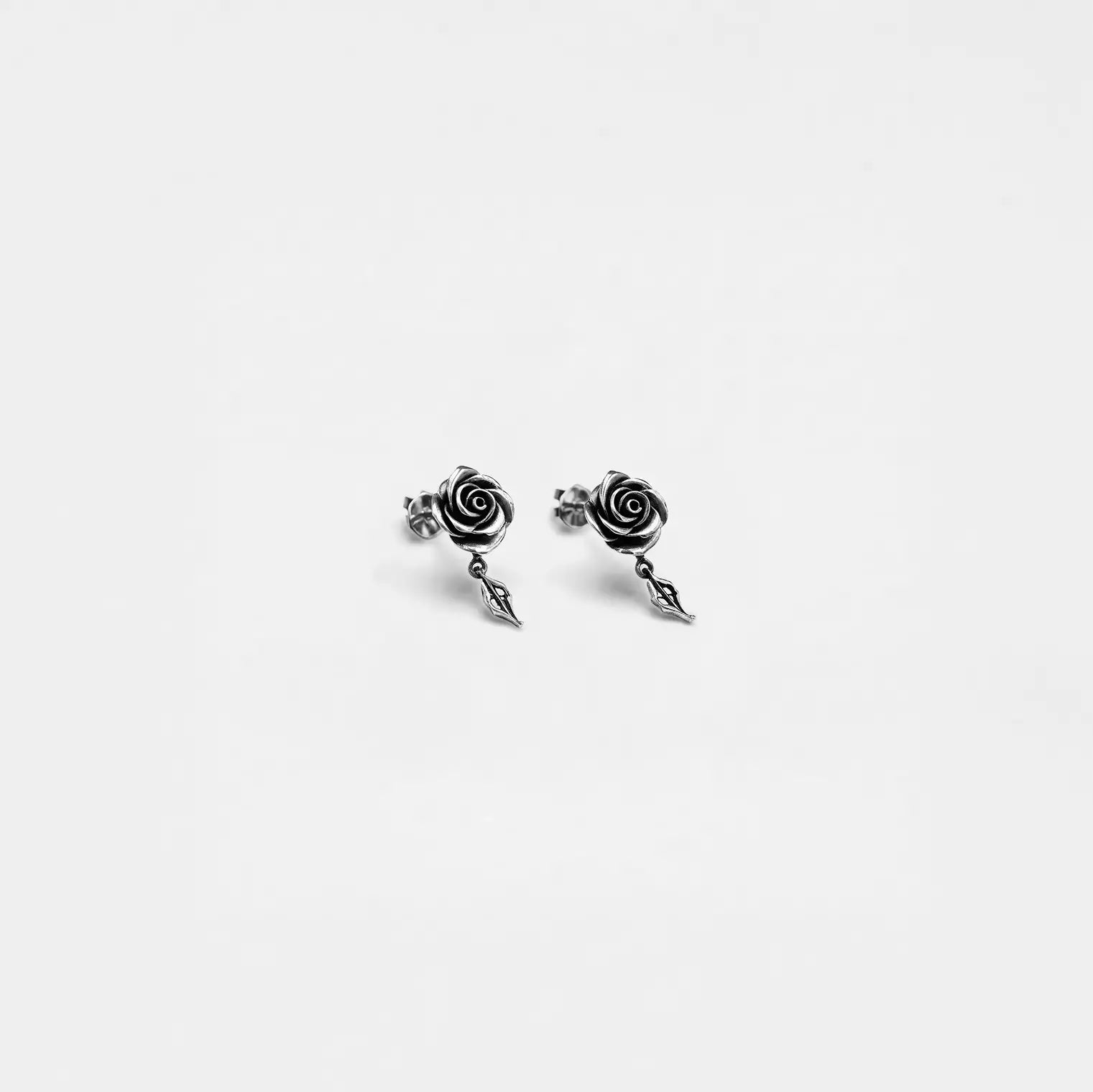 Pair of silver riose earrings on a white background