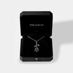 Silver necklace with a rose pendant in a black Tikalkun jewelry box on a light gray background