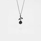 Silver necklace with a rose pendant on a light gray background