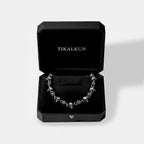 Silver necklace in an open black Tikalkun jewelry box on a light gray background
