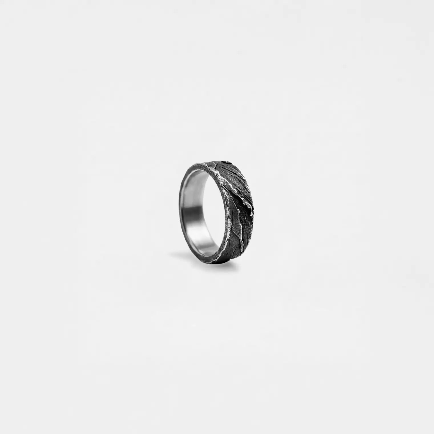 Silver ring with rustic textured band on a light gray background