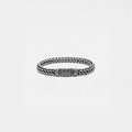 Silver braided bracelet on a light gray background