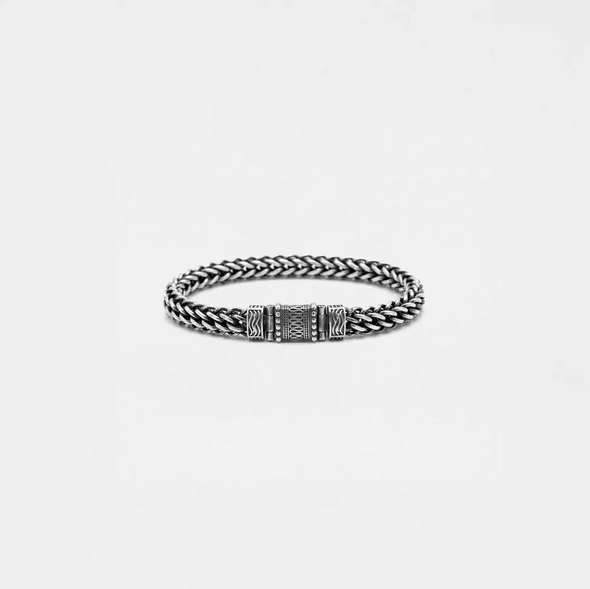 Silver braided bracelet on a light gray background