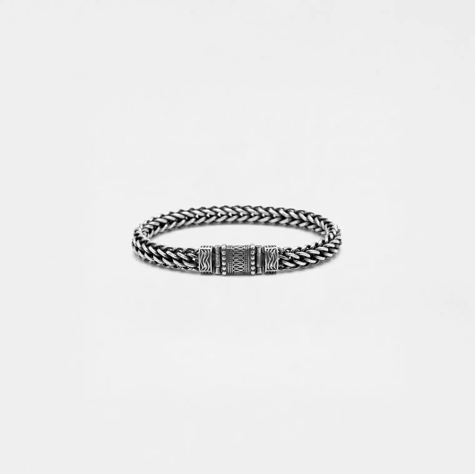 Silver braided bracelet on a light gray background