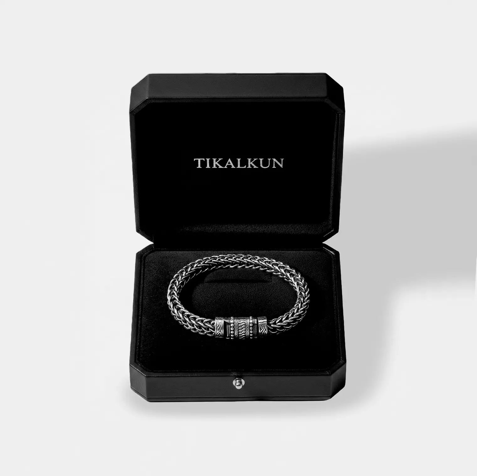 Silver bracelet in an open black Tikalkun box on a light gray background