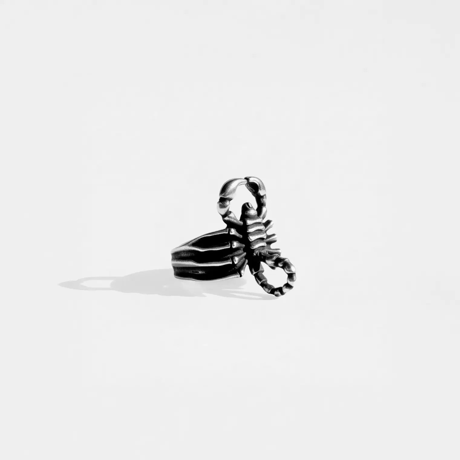 Silver scorpion-shaped ring on a white background