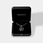 Scorpion silver necklace in a black Tikalkun jewelry box on a light gray background