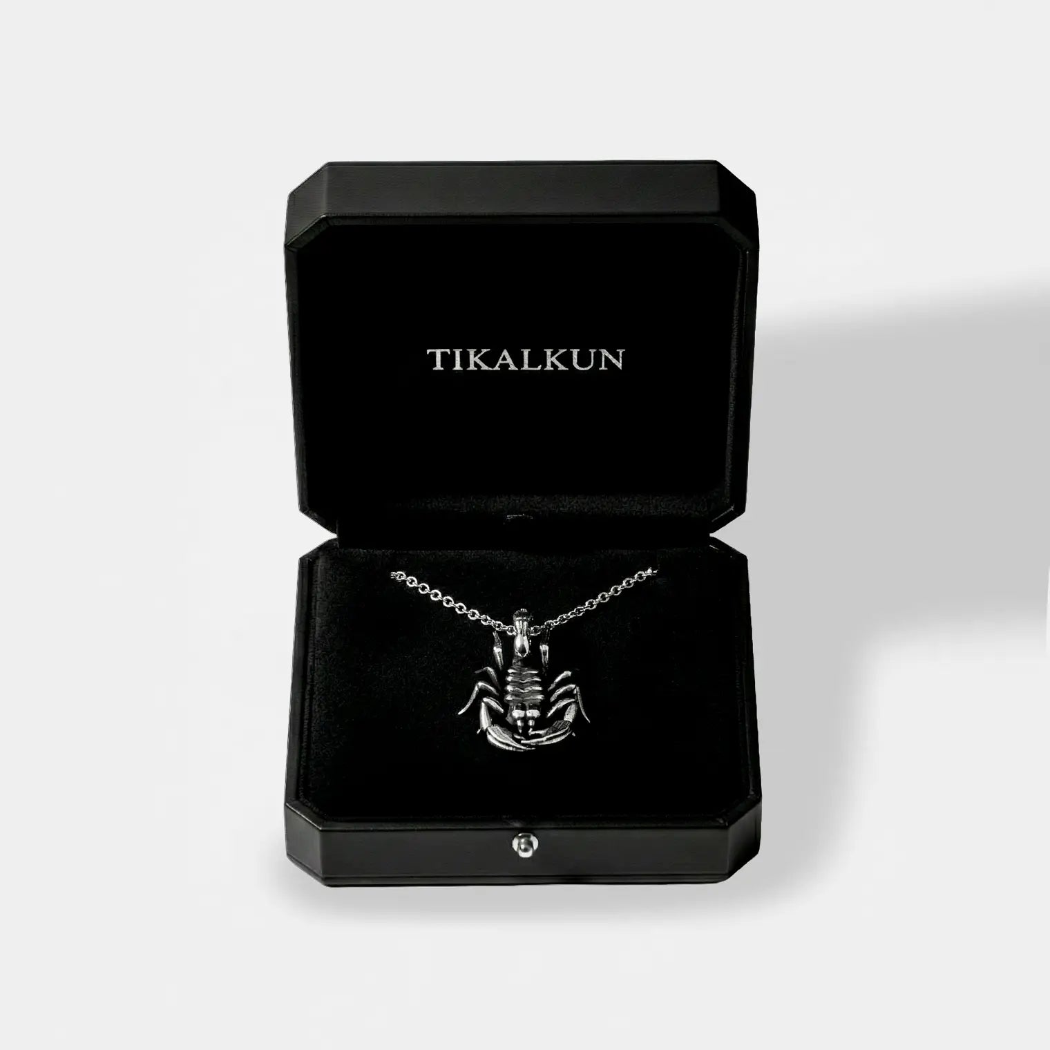 Scorpion silver necklace in a black Tikalkun jewelry box on a light gray background