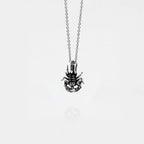 Silver scorpion pendant necklace on a thin chain against a white background