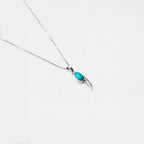 Necklace with a turquoise feather pendant on a white background