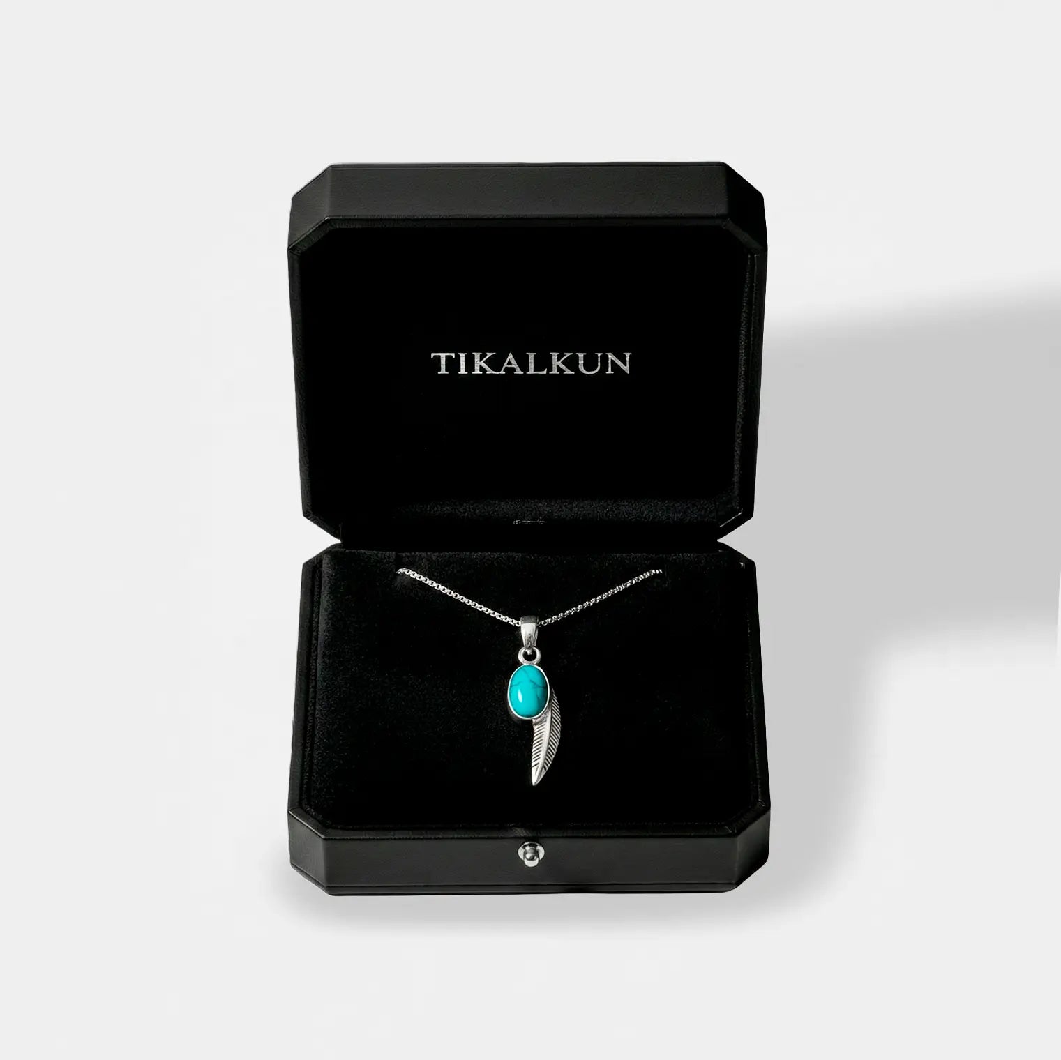 Jewelry box with a necklace featuring a turquoise pendant and 'TIKALKUN' branding.