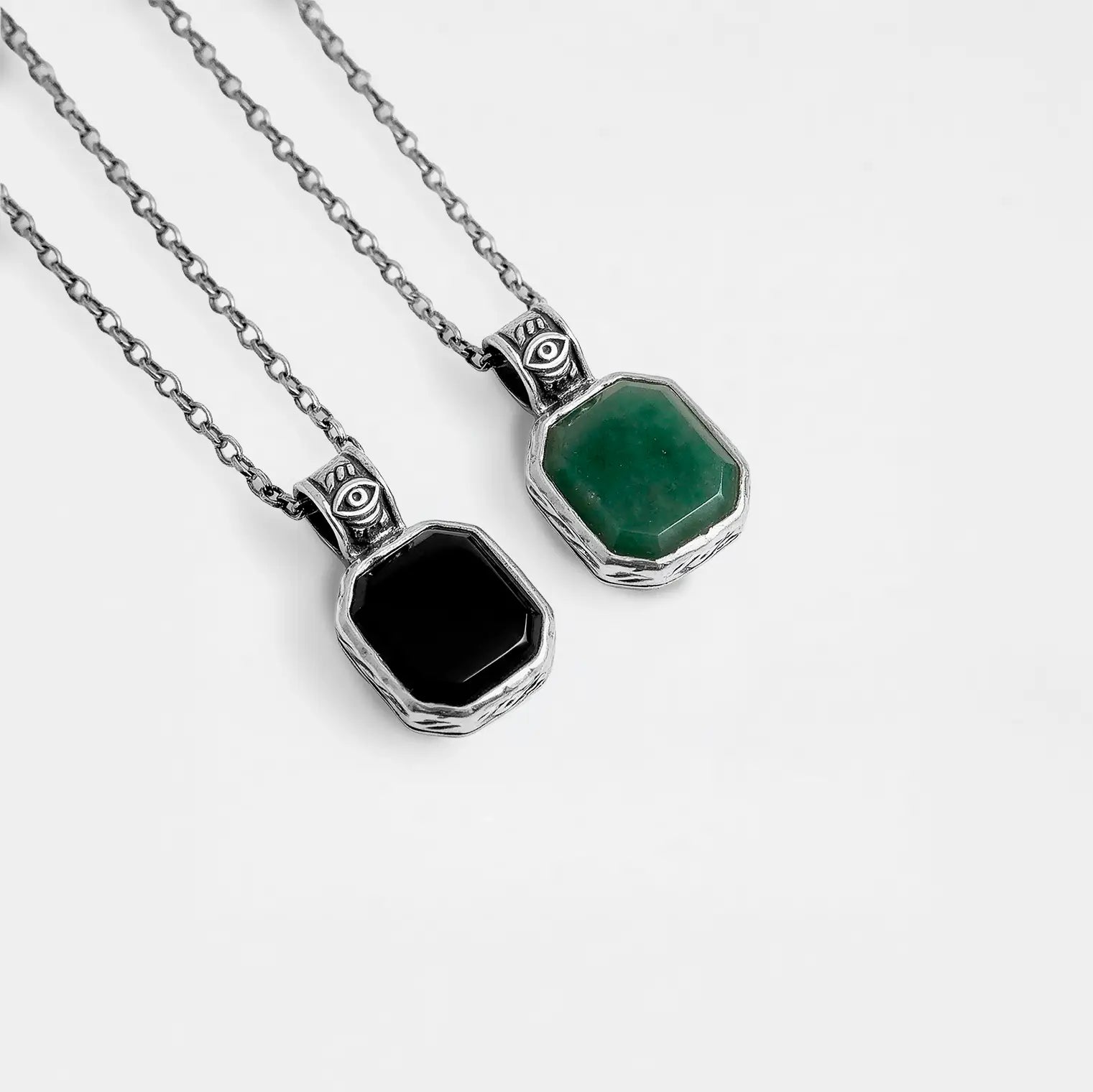 Two necklaces with hexagonal pendants, one jade and one obsidian, on a white background.