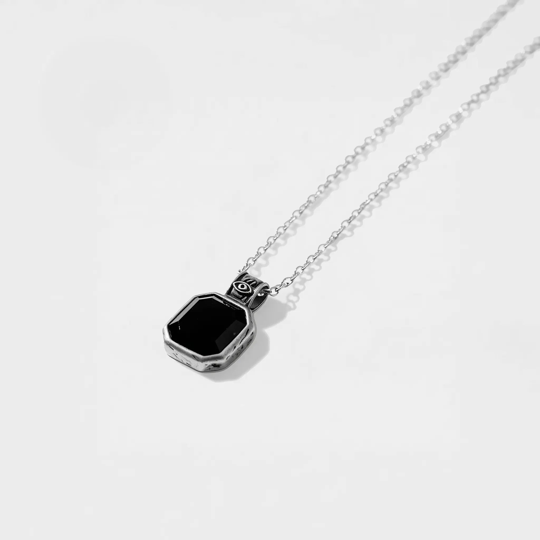 Silver necklace with an obsidian pendant on a light gray background