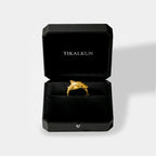 Gold tiger-shark ring in a black Tikalkun jewelry box on a light gray background
