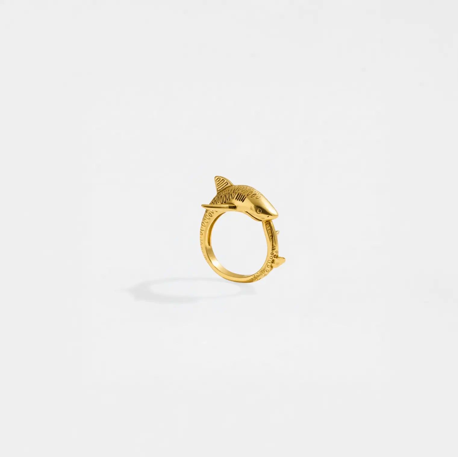 Gold ring with a tiger-shark design on a white background