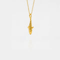 Gold tiger-shark pendant on a chain against a white background