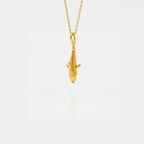 Gold tiger-shark pendant on a chain against a white background