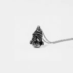 Silver tlaloc pendant with chain on a light gray background