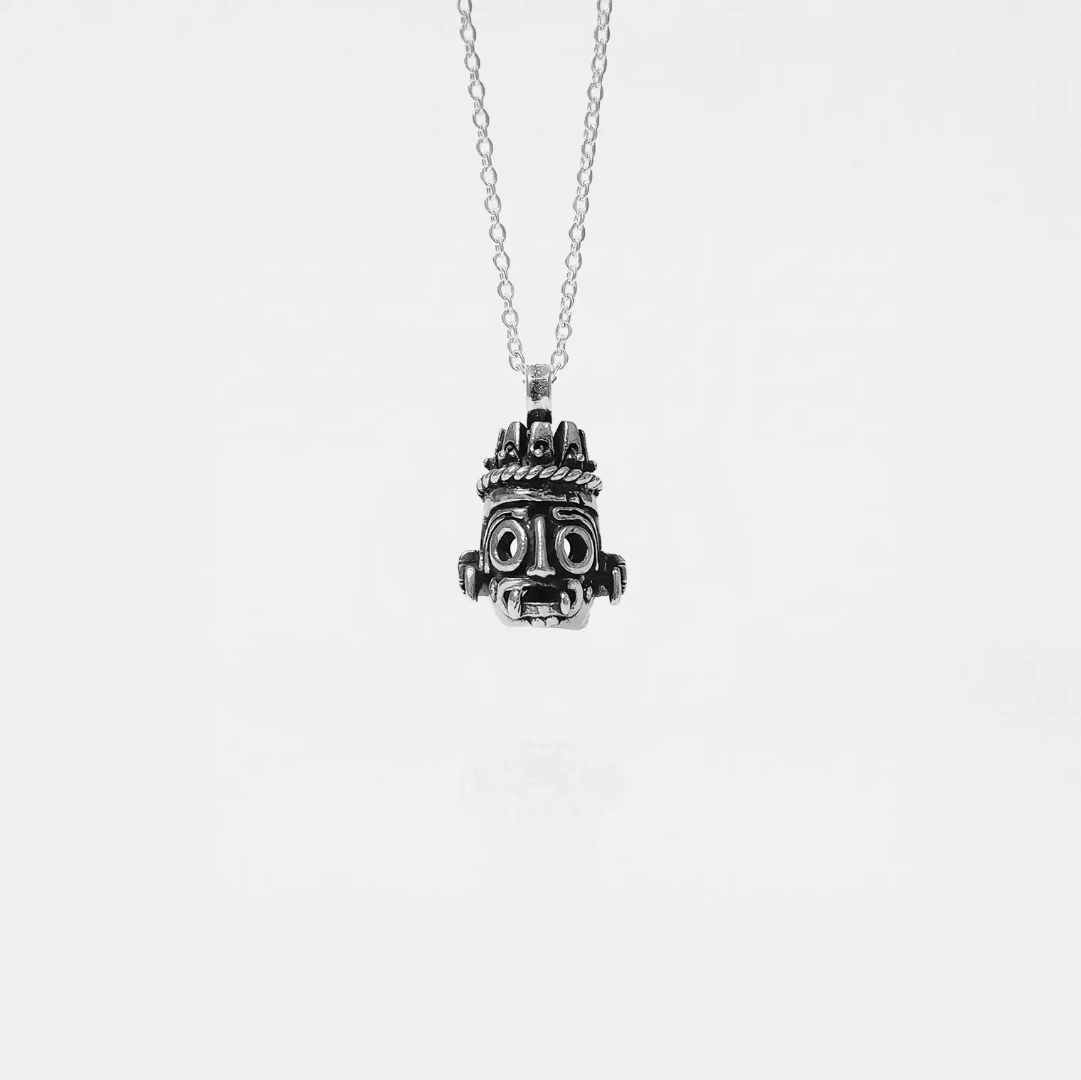 Silver tlaloc pendant necklace on a white background