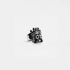 Metallic ring with a tlaloc design on a white background