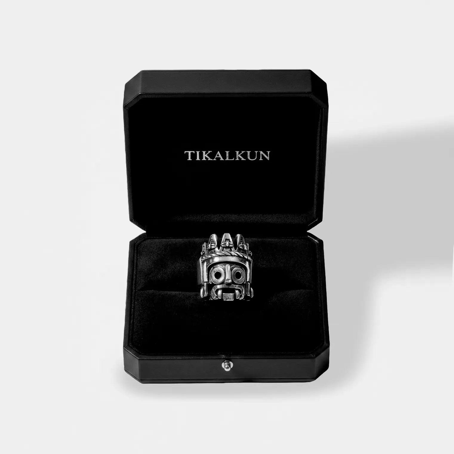 Silver tlaloc ring in a black Tikalkun jewelry box on a light gray background