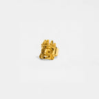 Gold ring with a tlaloc design on a white background