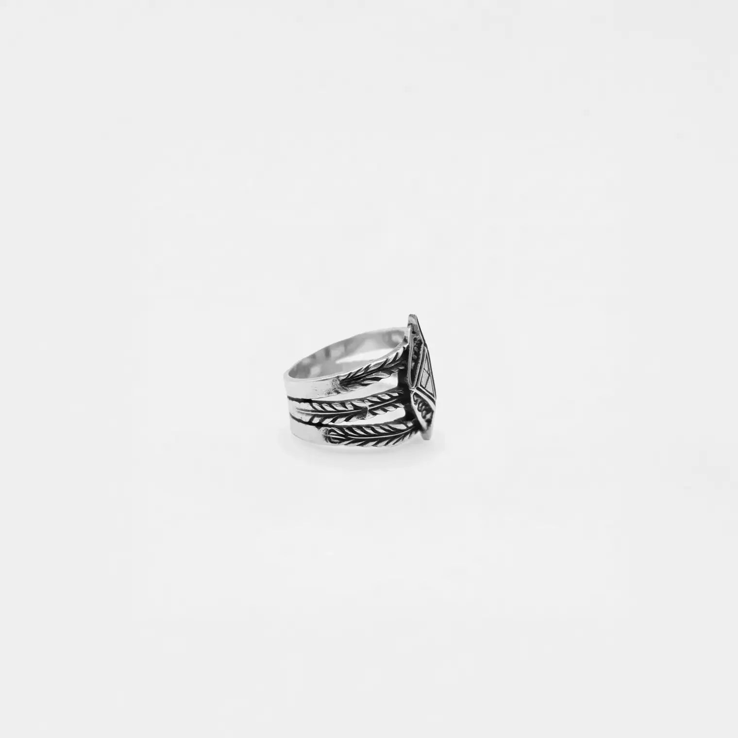 Silver ring with tribal design on a white background
