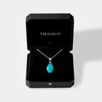 Turquoise pendant necklace in a black Tikalkun jewelry box on a white background